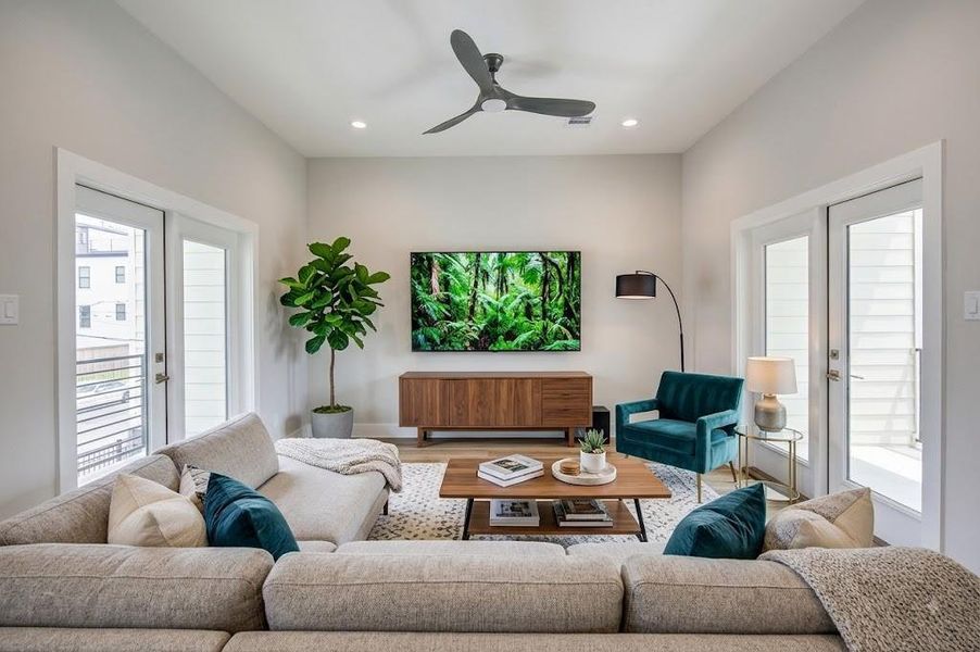 Bright and inviting living room with large patio doors leading to two balconies on both sides.