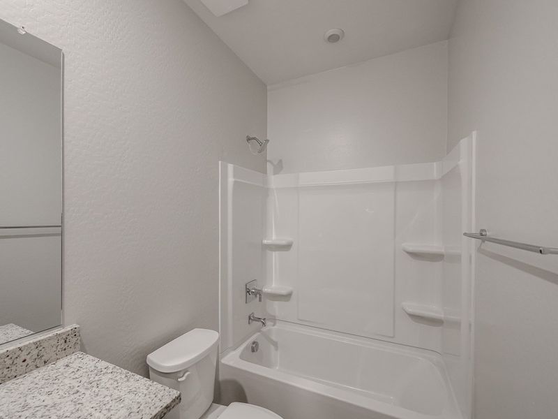 A bathroom with a tub toilet and sink.