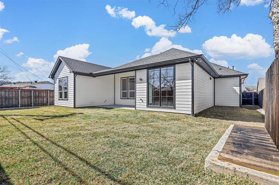 Back of property with a lawn and a patio area