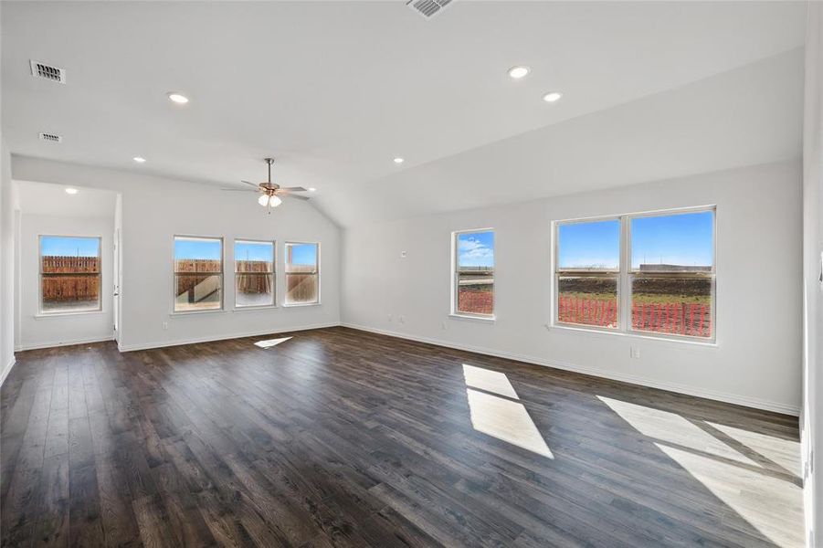 Unfurnished living room with lofted ceiling, dark wood finished floors, healthy amount of natural light, recessed lighting, and ceiling fan
