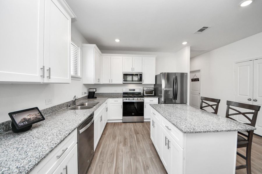 Greeted by open floor plan kitchen/dining/living area