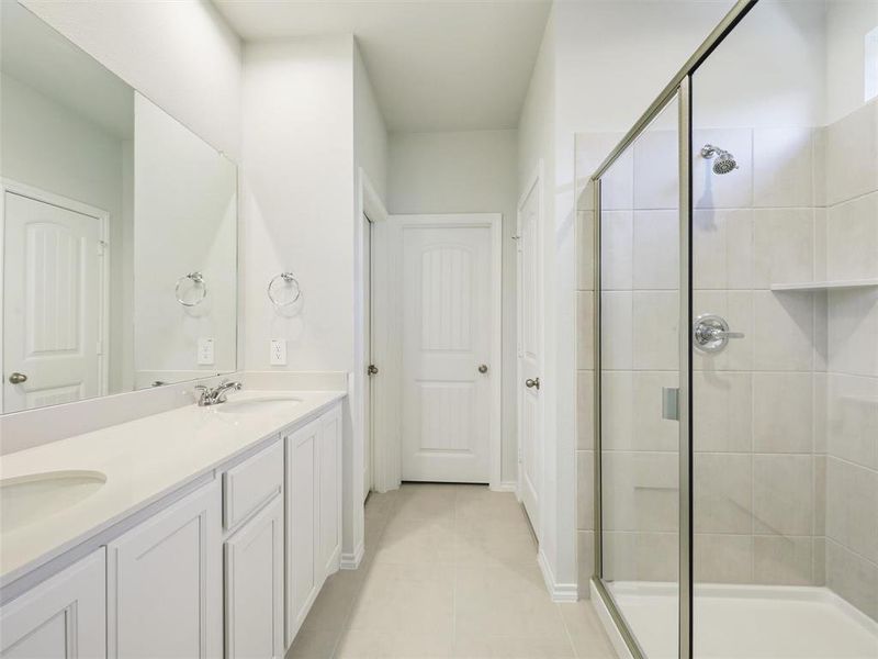 Full bathroom featuring a shower stall, tile patterned flooring, double vanity, and a sink Full bathroom featuring a shower stall, tile patterned flooring, double vanity, and a sink