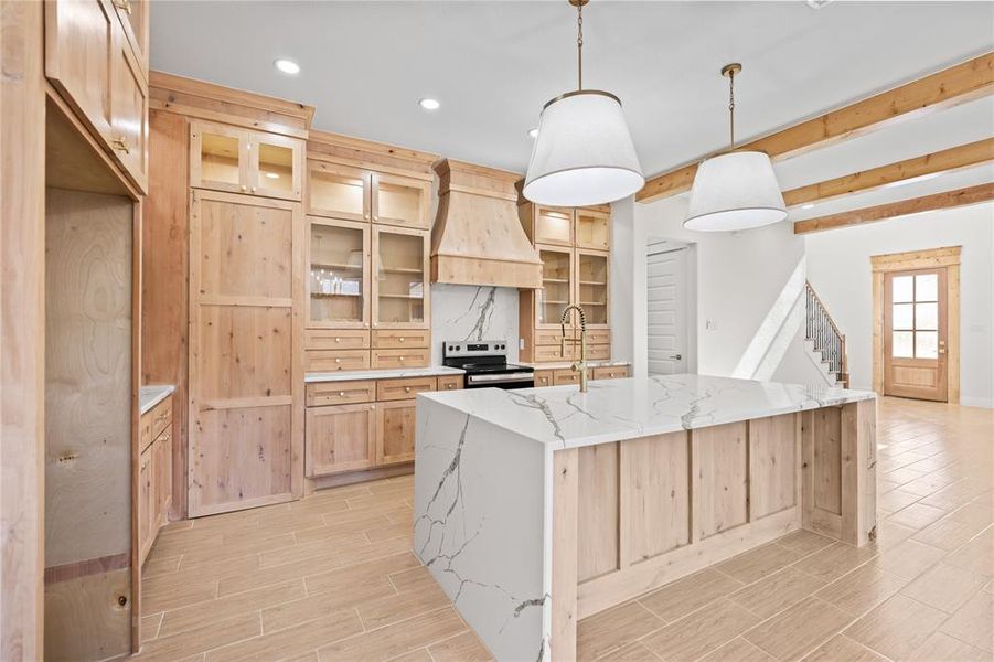 Kitchen with light wood finish cabinets, glass fronted cabinets, wood tiled floors, light stone countertops, and pendant lighting Kitchen with light wood finish cabinets, glass fronted cabinets, wood tiled floors, light stone countertops, and pendant lighting