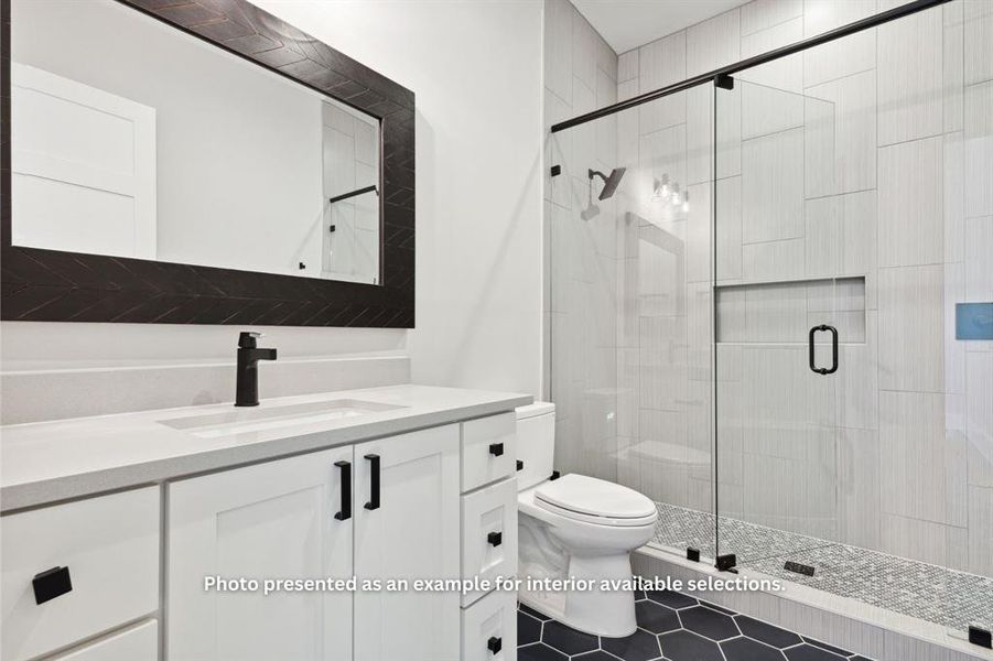 Bathroom with tile floors, a shower with shower door, vanity, and toilet