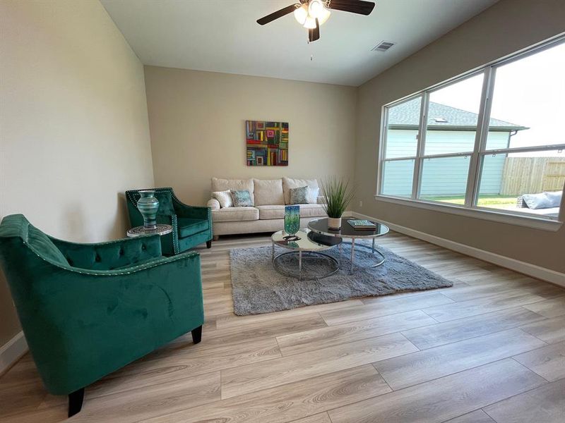 This living room space features an expansive, light-filled area with large windows and a versatile layout perfect for both entertaining and everyday living.