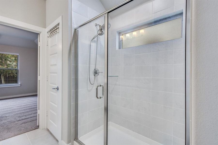 Bathroom featuring carpet floors, a shower stall, and tile patterned floors Bathroom featuring carpet floors, a shower stall, and tile patterned floors