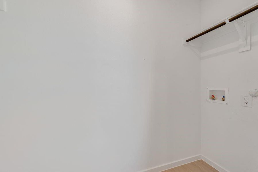 Laundry area with light wood-style flooring and hookup for a washing machine