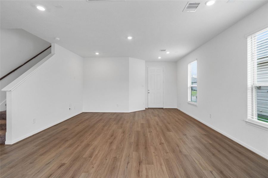 This bright and airy Great Room offers a spacious layout ideal for both relaxing evenings and lively gatherings. Designed for comfort and connection, it features Layton Lake Wild Dunes vinyl plank flooring, large windows, high ceilings, recessed lighting, and seamless access to the kitchen and dining—perfect for everyday living and entertaining alike.