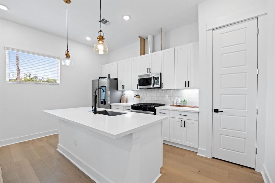 This open-concept kitchen exudes modern elegance, featuring sleek stainless steel appliances that seamlessly blend with the contemporary design. This open-concept kitchen exudes modern elegance, featuring sleek stainless steel appliances that seamlessly blend with the contemporary design.