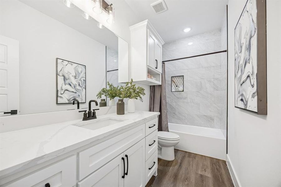 Bathroom with vanity, shower / bath combination with curtain, and dark wood-style flooring