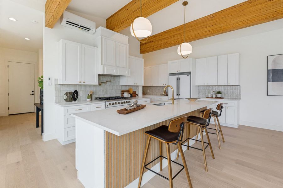 Blonde wood beams complement wide plank hardwood floors in this bright, open concept living space.