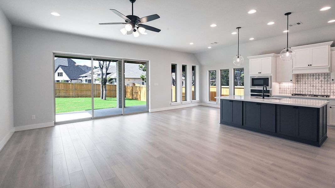 Kitchen featuring white cabinetry, recessed lighting, decorative backsplash, an island with sink, and decorative light fixtures