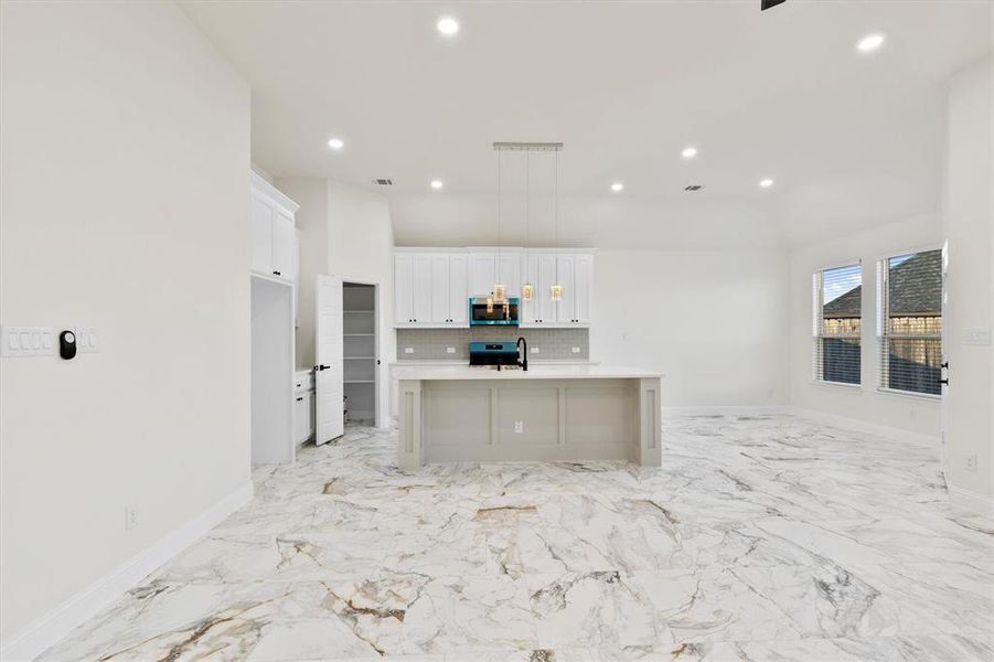 Kitchen with recessed lighting, white cabinets, light countertops, appliances with stainless steel finishes, and decorative backsplash Kitchen with recessed lighting, white cabinets, light countertops, appliances with stainless steel finishes, and decorative backsplash