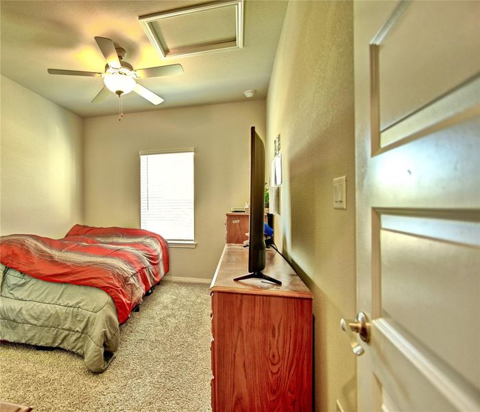 Bedroom with a ceiling fan and light carpet Bedroom with a ceiling fan and light carpet
