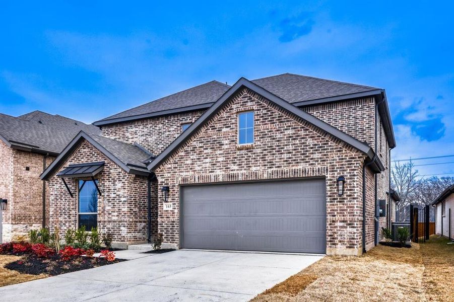 View of front of house featuring brick siding, driveway, a shingled roof, and an attached garage