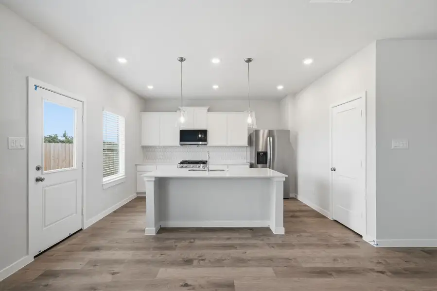 A kitchen with white cabinets.