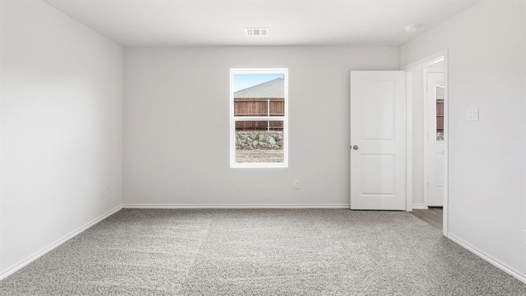 This room features light gray walls, a window providing natural light, and gray carpeted flooring
