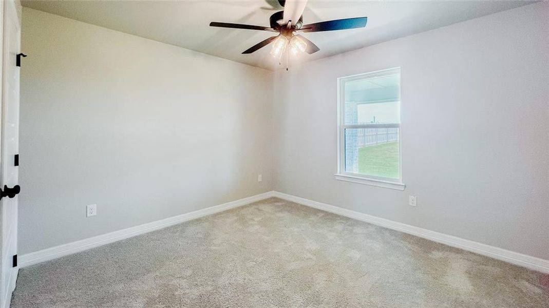 Empty room featuring carpet flooring and a ceiling fan Empty room featuring carpet flooring and a ceiling fan