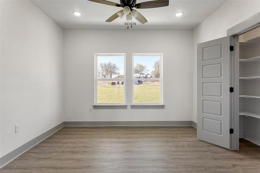 Unfurnished bedroom with ceiling fan and light hardwood / wood-style flooring