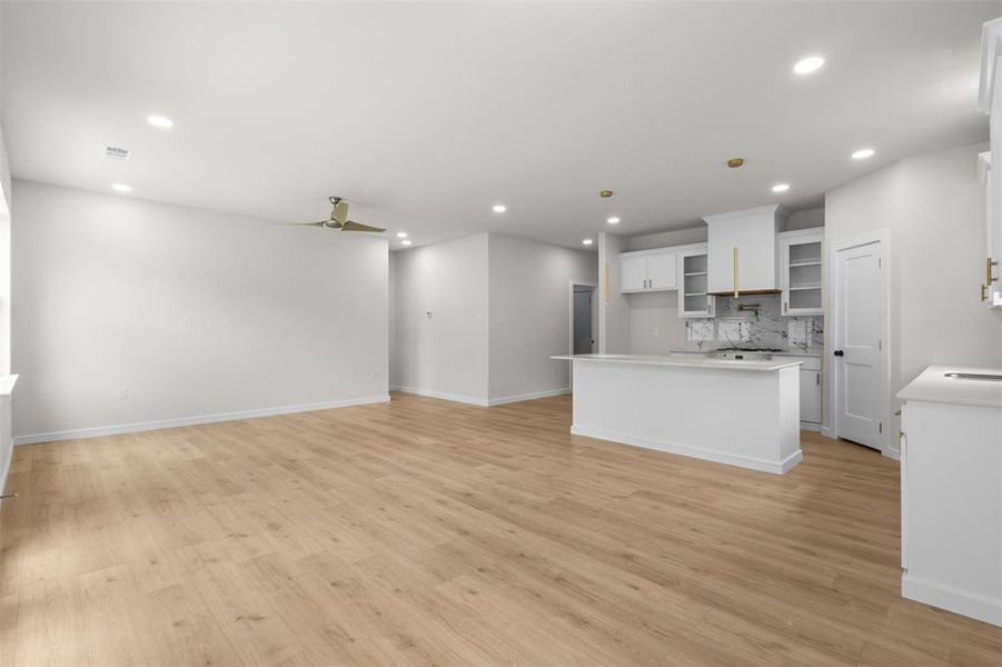 Open-concept living space featuring wood-finish flooring, recessed lighting, and a contemporary ceiling fan