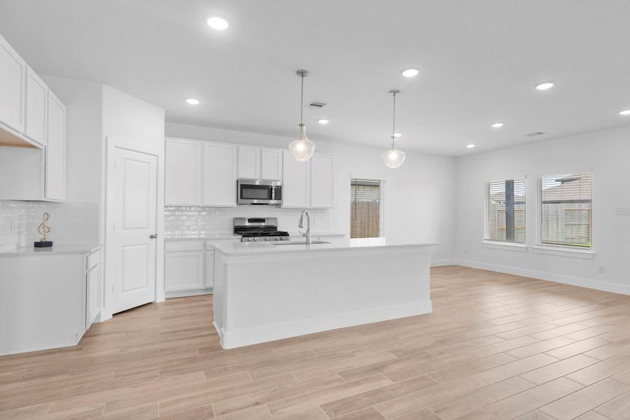 Stylish kitchen view showcasing tall white shaker cabinets, quartz countertops, and a large island with pendant lighting—make this your home, call now! Stylish kitchen view showcasing tall white shaker cabinets, quartz countertops, and a large island with pendant lighting—make this your home, call now!