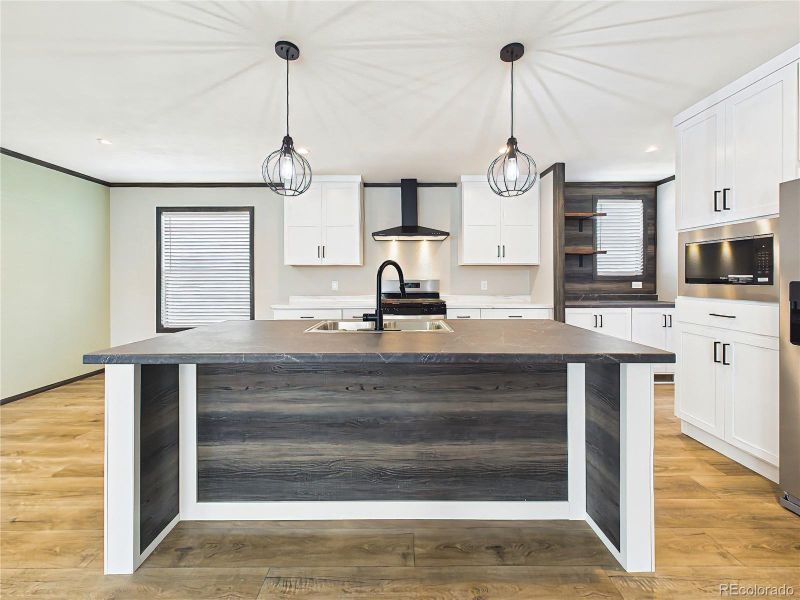 Kitchen Island – Spacious island with dual-basin sink, ample prep space, and bar seating, ideal for everyday use and entertaining.