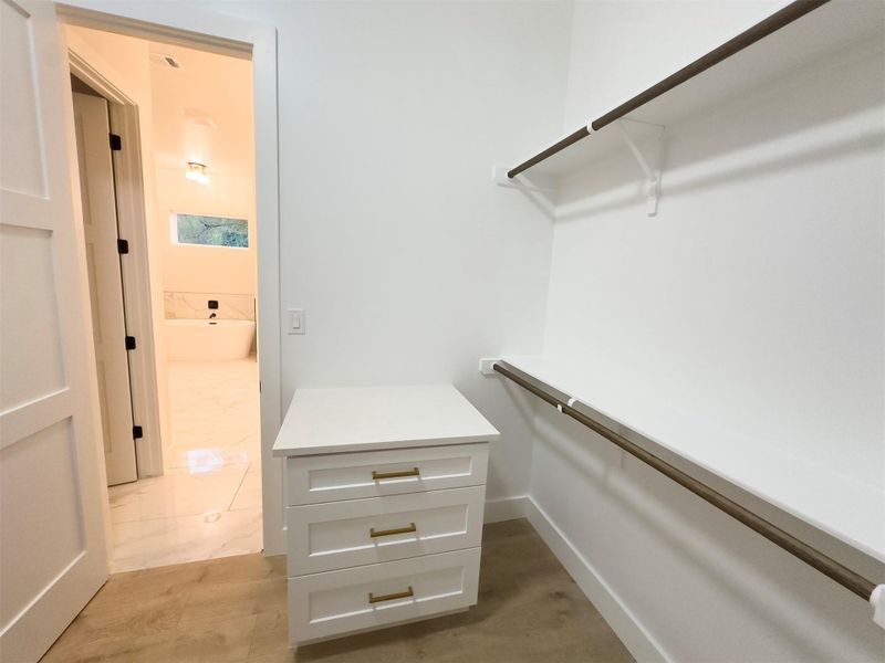Ample built-in shelving and custom drawers organize this spacious walk-in closet space. Ample built-in shelving and custom drawers organize this spacious walk-in closet space.