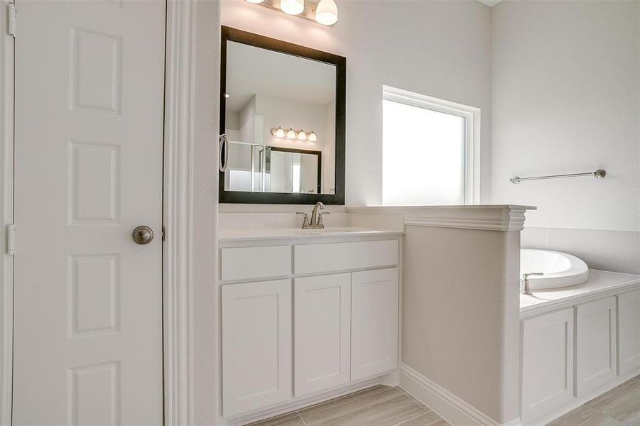 Bathroom featuring vanity, shower with separate bathtub, and hardwood / wood-style floors