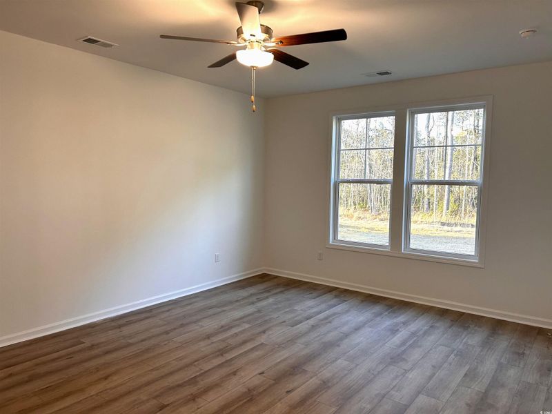 Empty room featuring wood finished floors and a ceiling fan