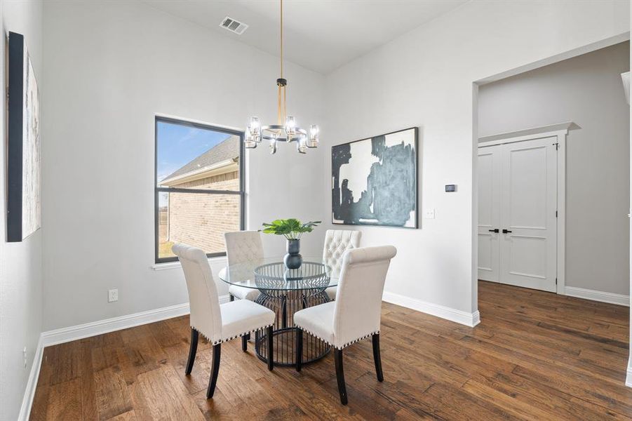 Dining area featuring dark wood-type flooring and a chandelier