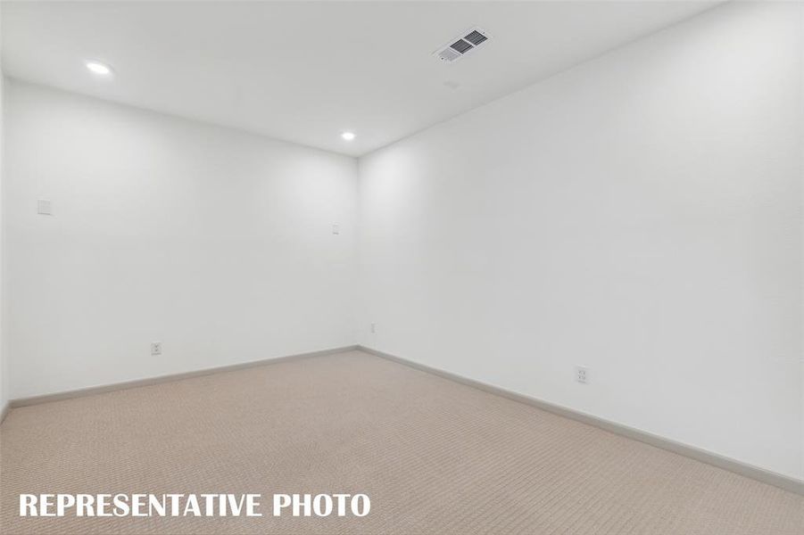 This spacious media room with adjacent game room create the ultimate family entertainment area!  REPRESENTATIVE PHOTO