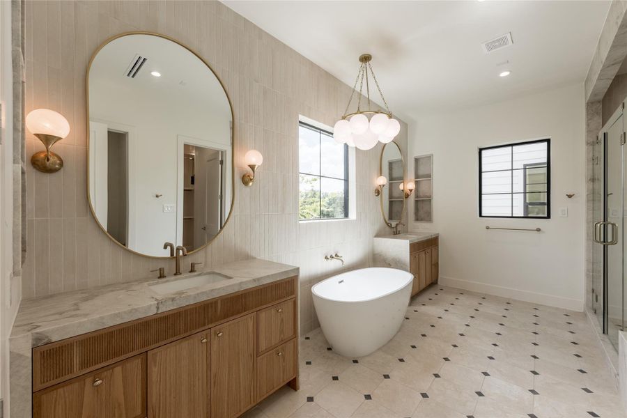 A wider perspective reveals the primary bath’s thoughtful symmetry, pairing dual vanities with a freestanding soaking tub and natural stone surfaces. Designer tile carries across the floor and walls, giving the ensuite a tailored, cohesive finish. A wider perspective reveals the primary bath’s thoughtful symmetry, pairing dual vanities with a freestanding soaking tub and natural stone surfaces. Designer tile carries across the floor and walls, giving the ensuite a tailored, cohesive finish.