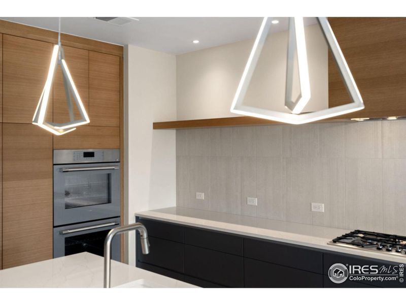 A sleek, modern kitchen with pendants that pop greet you.