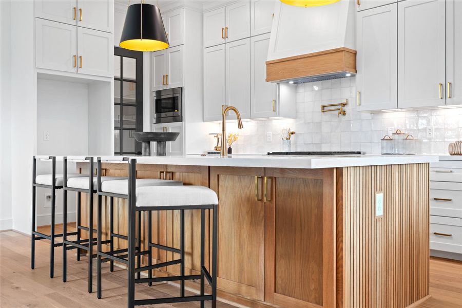 Custom cabinetry beneath the island offers thoughtful extra storage, ideal for organizing entertaining pieces or setting up dedicated areas for guests. Custom cabinetry beneath the island offers thoughtful extra storage, ideal for organizing entertaining pieces or setting up dedicated areas for guests.