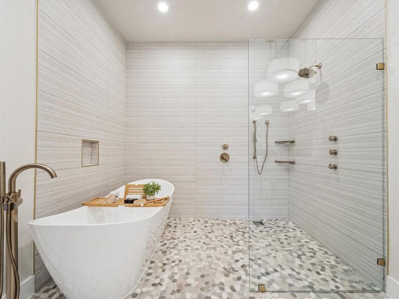 Bathroom featuring tile patterned flooring, plus walk in shower, tile walls, and sink