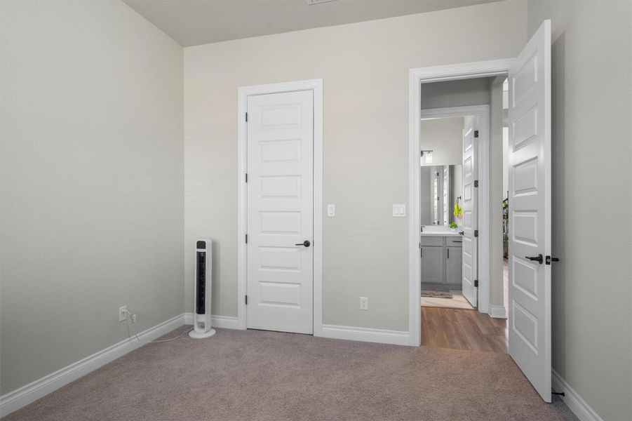 Soft carpeting and crisp baseboards anchor this versatile bedroom workspace near the bathroom.