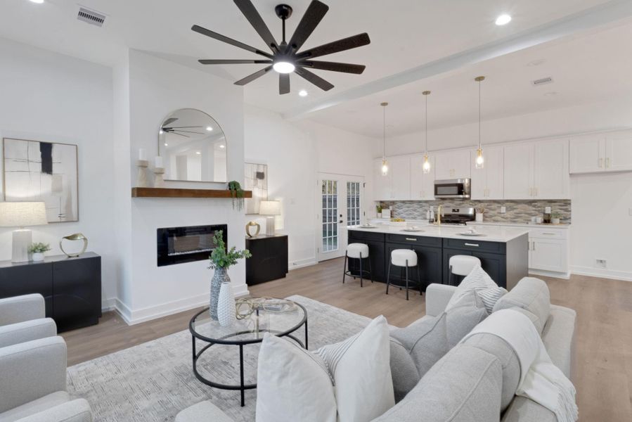 Inviting living room with large windows, a modern electric fireplace, and a wood mantel that adds warmth and character to the space. Inviting living room with large windows, a modern electric fireplace, and a wood mantel that adds warmth and character to the space.