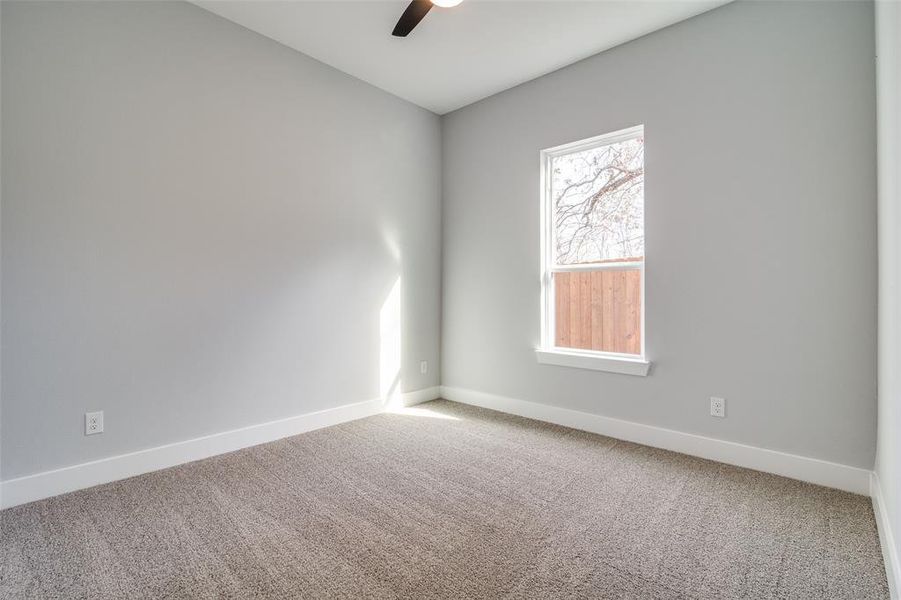 Unfurnished room featuring ceiling fan and carpet floors