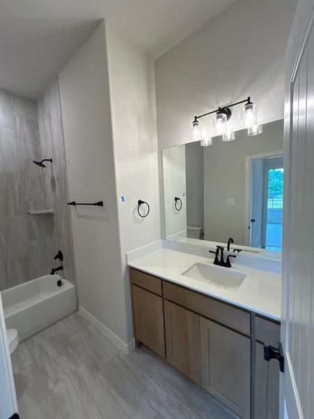 Bathroom featuring a wood-finish vanity with a white countertop and undermount sink