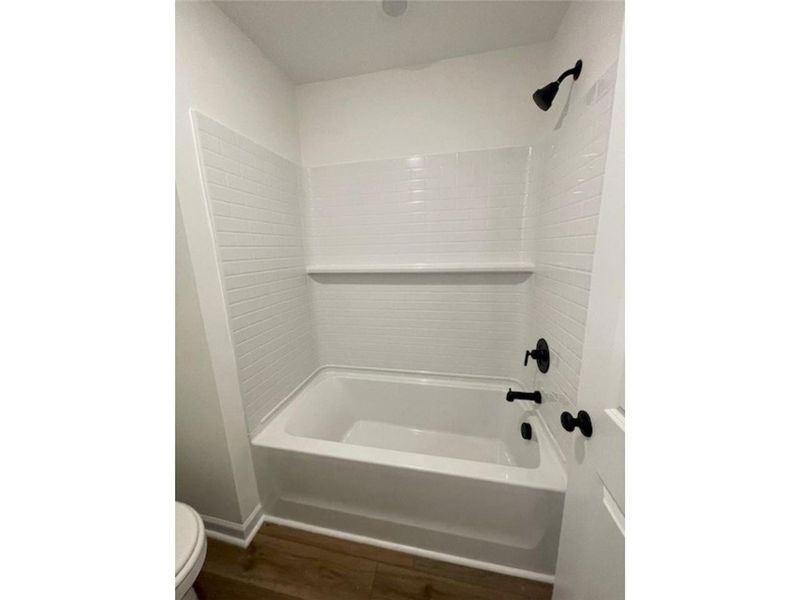This bathroom features a sleek tub and shower comb