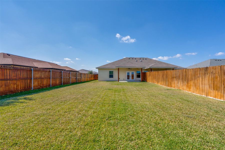 Rear view of property featuring a patio area, a fenced backyard, french doors, and stucco siding Rear view of property featuring a patio area, a fenced backyard, french doors, and stucco siding