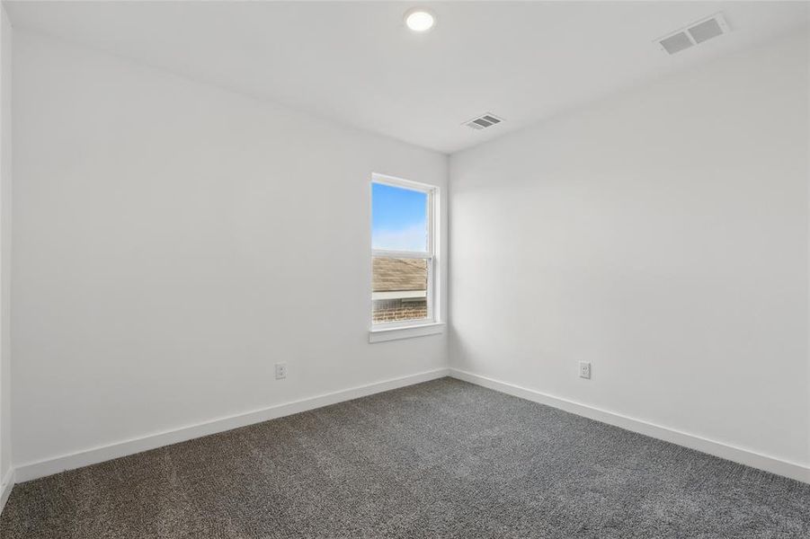 Spare room with dark colored carpet and recessed lighting