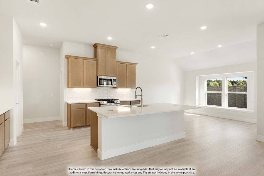 Open kitchen with wood cabinets, white island with sink, and stainless appliances, open to living area with light hardwood floors Open kitchen with wood cabinets, white island with sink, and stainless appliances, open to living area with light hardwood floors