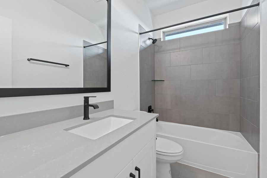 Full bathroom featuring shower / bath combination, vanity, and dark tile patterned flooring