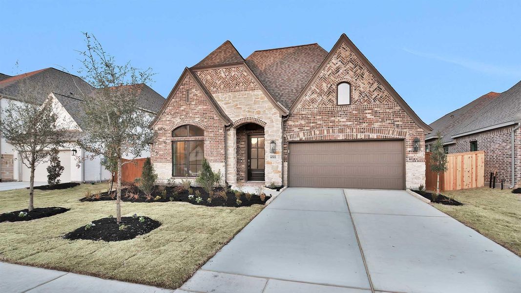 Front exterior of a new home in Meridiana, Manvel, TX, highlighting curb appeal (Image 2).