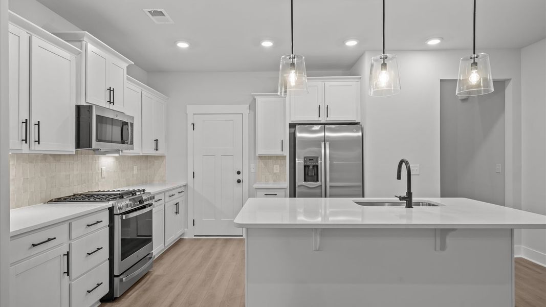 Exclusive kitchen design with large island, pendant lights, and tasteful finishes throughout Exclusive kitchen design with large island, pendant lights, and tasteful finishes throughout