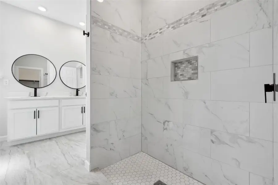 Bathroom with vanity, a tile shower, recessed lighting, and marble finish flooring Bathroom with vanity, a tile shower, recessed lighting, and marble finish flooring