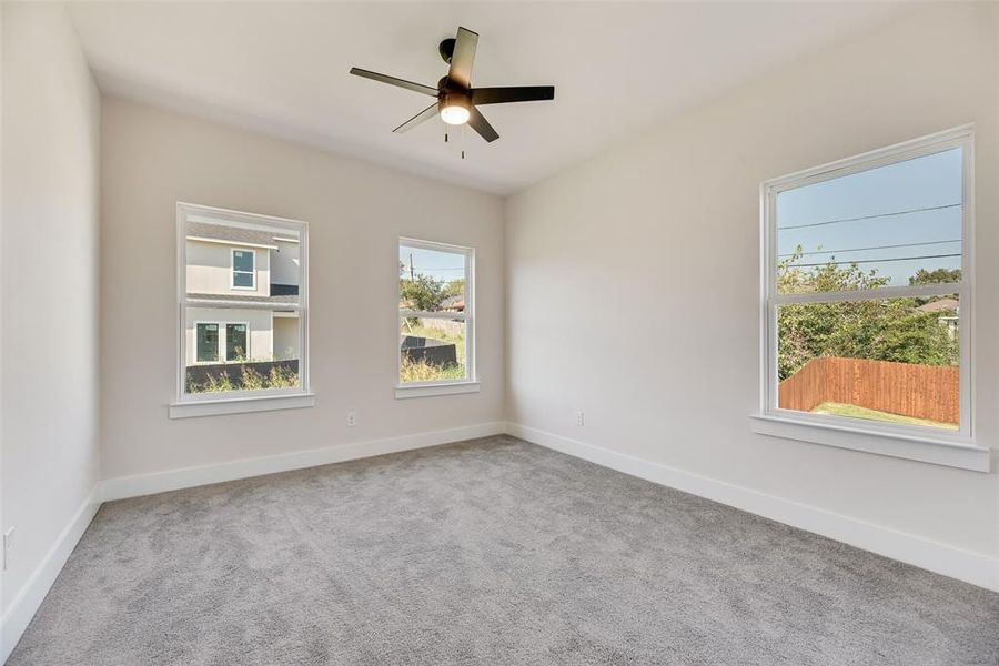 Spare room featuring light colored carpet and a ceiling fan Spare room featuring light colored carpet and a ceiling fan