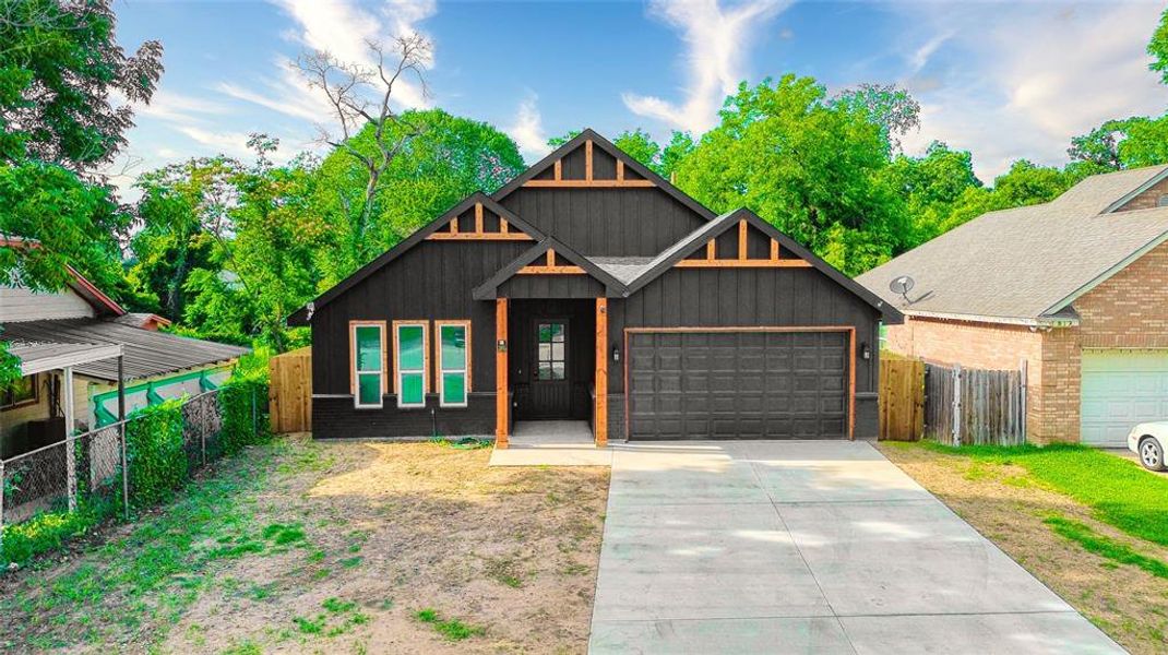 View of front facade featuring a garage, concrete driveway, and board and batten siding