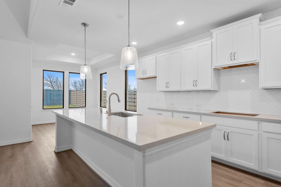 The oversized island with pendant lights is ready for relaxing breakfast and study sessions.